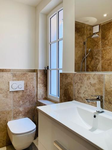 une salle de bain avec un lavabo et des toilettes et une fenêtre dans l'établissement Maison Saint-Tropez, à Saint-Tropez