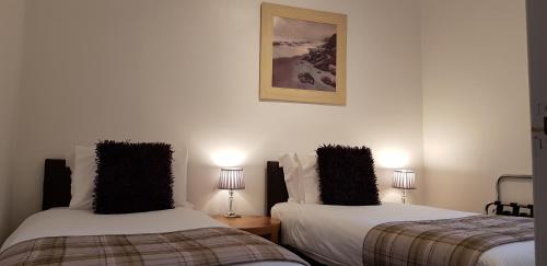 two beds sitting next to each other in a room at Auld Leigh-Lann Apartments in Anstruther