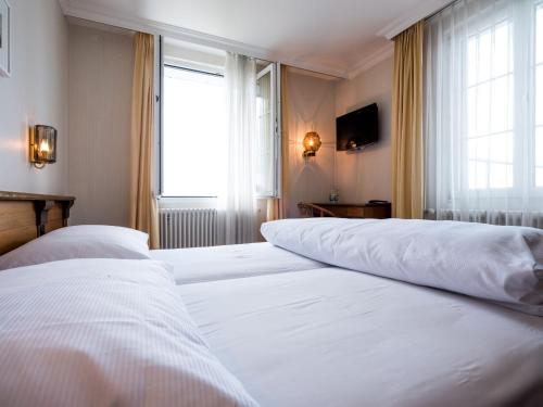 two beds in a hotel room with a window at Landgasthof Hotel Menzberg in Menzberg