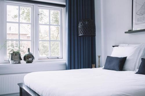 a bedroom with a white bed and a window at B&B Logeren bij Lies in Harderwijk