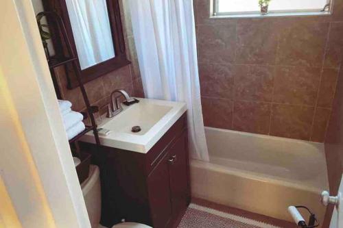 La salle de bains est pourvue d'un lavabo et d'une baignoire. dans l'établissement Private single family home - 10 minutes from beach, à Pompano Beach