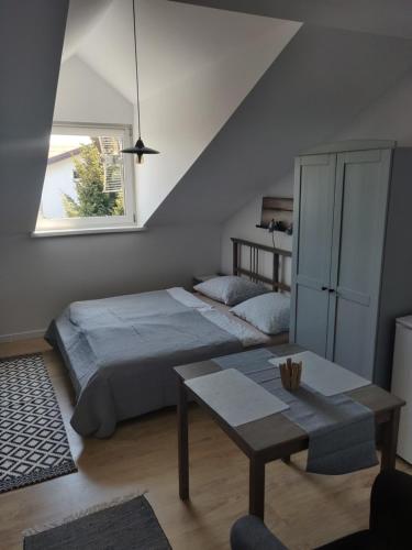 um quarto com uma cama, uma mesa e uma janela em Ostrowianka em Ostrowo