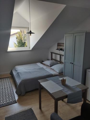 a bedroom with a bed and a table and a window at Ostrowianka in Ostrowo