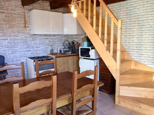 a kitchen with a staircase leading up to a kitchen with a table at grasset rittiron in Ouides