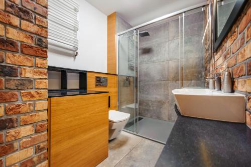 グディニャにあるApartament Art Deco 2のレンガの壁、洗面台付きのバスルーム