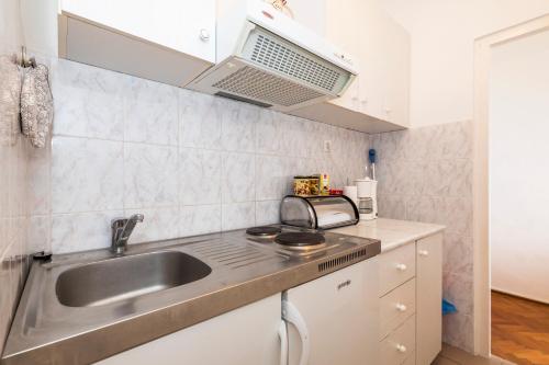a kitchen with a sink and a microwave at Apartment Muzic in Mali Lošinj