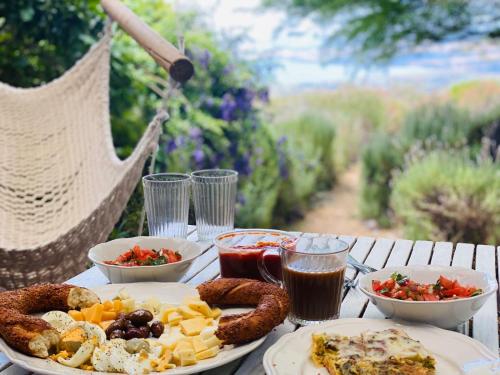 une table avec deux assiettes de nourriture et de saucisses dans l'établissement green island, à Ma'ale Gamla