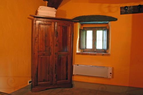 an orange room with a wooden cabinet and a window at Podere Pian De' Cortini in Serravalle