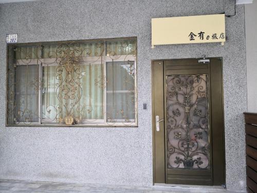 a door to a building with a sign on it at Jinyou B&B in Chishang