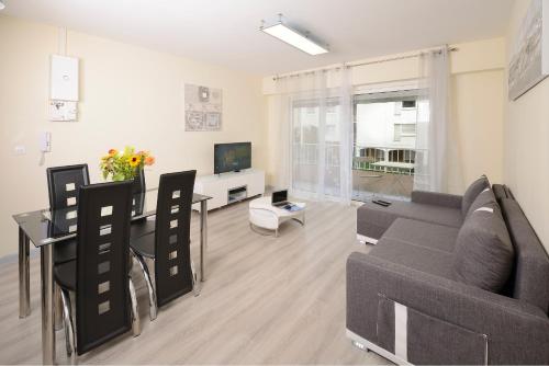 een woonkamer met een bank, een tafel en een televisie bij Appartement 2 chambres Angers Centre de Congrès in Angers