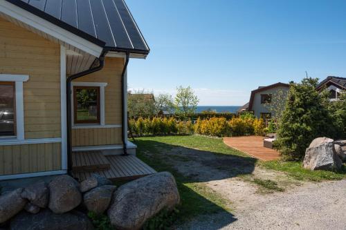 a house with a porch with rocks next to it at Klaukse in Kolga-Aabla
