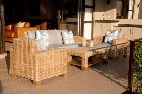 a group of wicker chairs and a table on a patio at Cathkin Haven in Champagne Valley