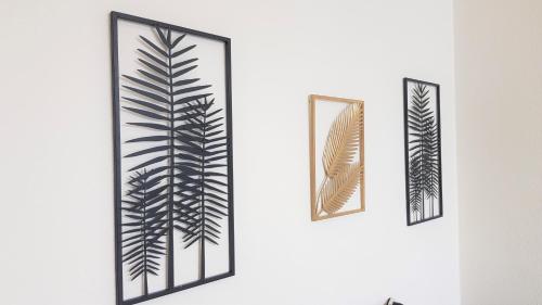 deux miroirs encadrés sur un mur ayant une conception végétale dans l'établissement Little Suite - Baptiste, à Lille