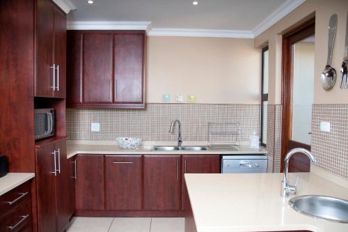a kitchen with wooden cabinets and a sink at Cathkin Haven in Champagne Valley