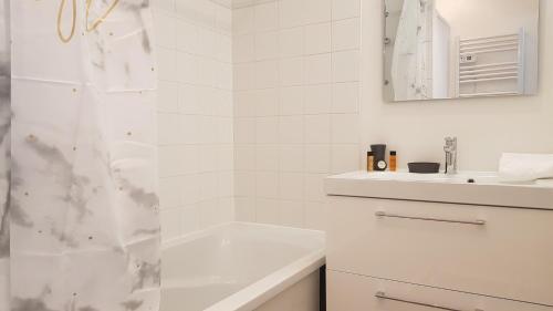 une salle de bain blanche avec une douche et un lavabo dans l'établissement Little Suite - Baptiste, à Lille