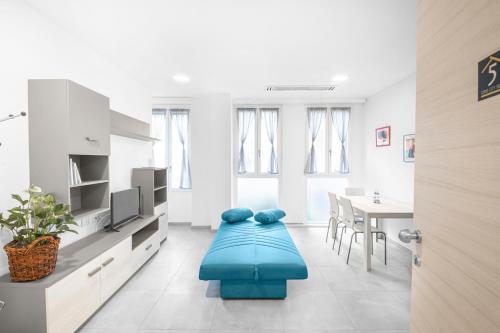 Como City Home في كومو: غرفة معيشة مع أريكة زرقاء وطاولة