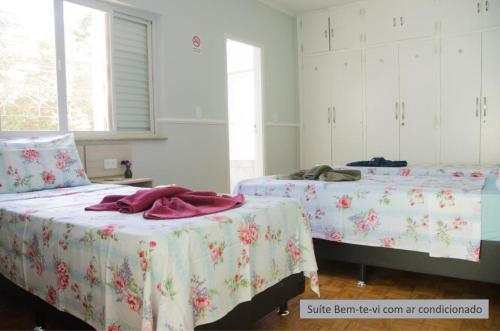 a bedroom with two beds with pink and white sheets at Pousada Happy Inn in Campinas