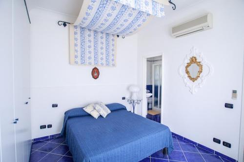 a bedroom with a blue bed and blue tile floors at Villino Dei Gerani in Capri