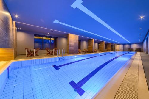 茲拉蒂博爾的住宿－Kalman SPA&GYM，蓝色灯光的酒店的大型游泳池