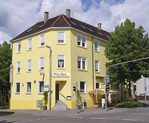 a yellow building on the corner of a street at Hotel Riviera in Ludwigsburg