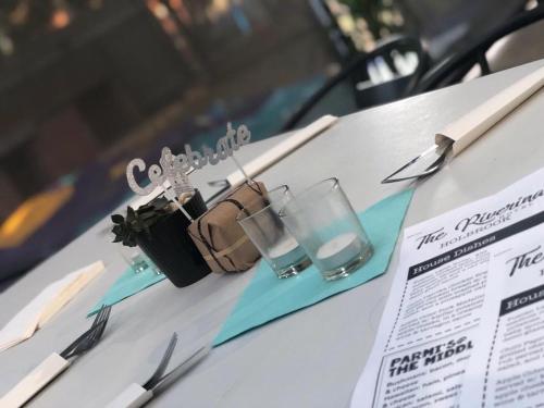 a table with two glasses and a purse on it at Riverina hotel in Holbrook