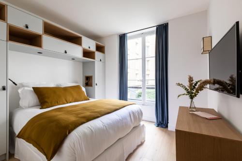 パリにあるPick A Flat's Apartment in Saint Germain - Rue Corneilleの白いベッドルーム(大型ベッド1台、窓付)