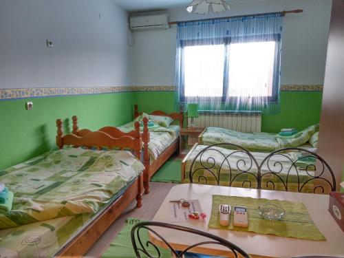 a room with three beds and a table and chairs at Apartment Harmonija apatin in Apatin