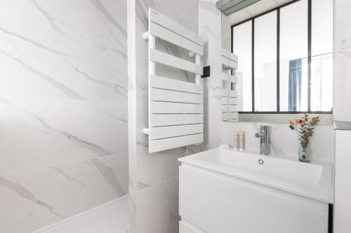 a white bathroom with a sink and a window at Pick A Flat's Apartment in Saint Germain - Rue Corneille in Paris