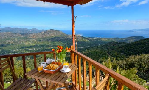 a table with a basket of food and flowers on a balcony at Traditional Windmill-Milos in Kroústas