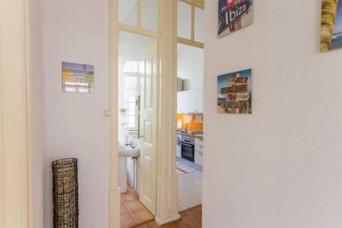 a hallway with a door leading to a kitchen at Cozy apartment at the city center in Figueira da Foz