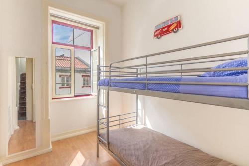 a bedroom with two bunk beds and a window at Cozy apartment at the city center in Figueira da Foz