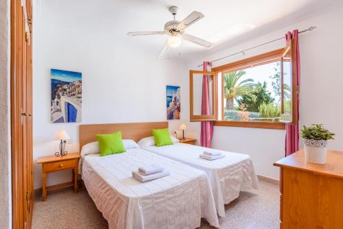 1 dormitorio con 2 camas y ventana en Villa Olivera en Son Bou