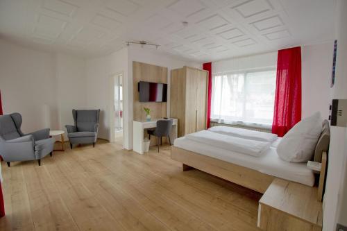 a bedroom with a bed and a desk and chairs at Hotel Garni Eckschänke in Bad Neuenahr-Ahrweiler