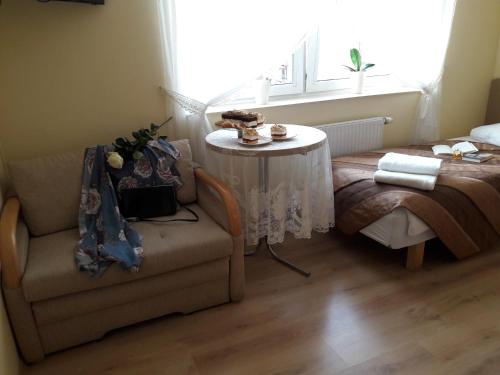 a living room with a couch and a table and a window at Hotel Finezja in Świdnik