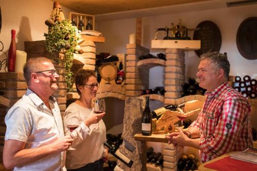 a group of people standing in a room with wine glasses at Hotel Bergfrieden in Martello