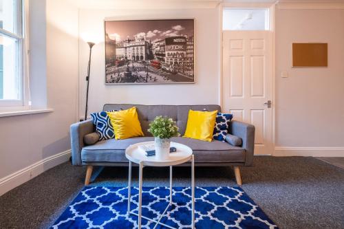 ein Wohnzimmer mit einem Sofa und einem Tisch in der Unterkunft Brunswick in Brighton and Hove by 9S Living in Brighton & Hove