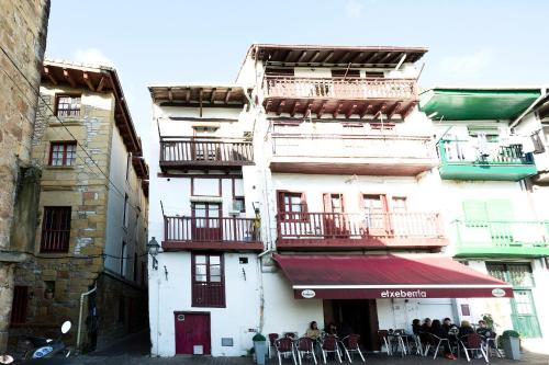 a building with tables and chairs in front of it at Txoriak - Basquenjoy in Hondarribia