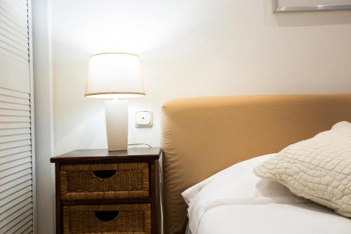 a lamp on a night stand next to a bed at Txoriak - Basquenjoy in Hondarribia