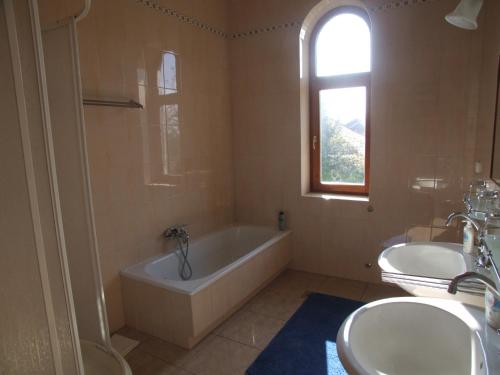 baño con 2 lavabos, bañera y ventana en Art Guesthouse, en Budapest