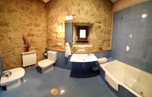 a bathroom with a sink and a tub and a toilet at Rectoral de Ansemil in Ansemil