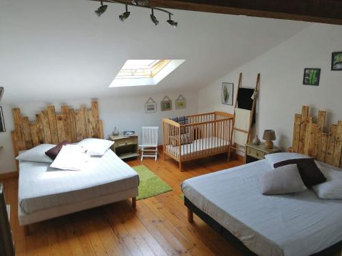 - une chambre avec 2 lits et un lit bébé dans l'établissement Les Gîtes de La Treille, à Montagrier