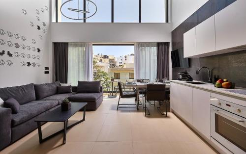 a kitchen and living room with a couch and a table at City Lion by Semavί in Heraklio Town