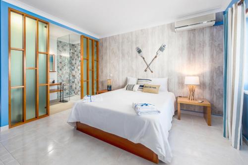 1 dormitorio con 1 cama blanca grande y espejo en Horta's villa - private heatable Pool en Lagos