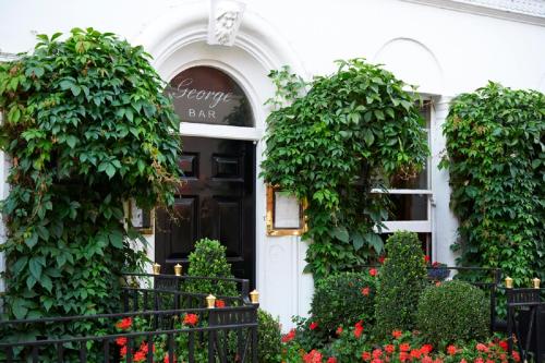 een voordeur van een wit gebouw met bloeiende planten bij Durrants Hotel in Londen