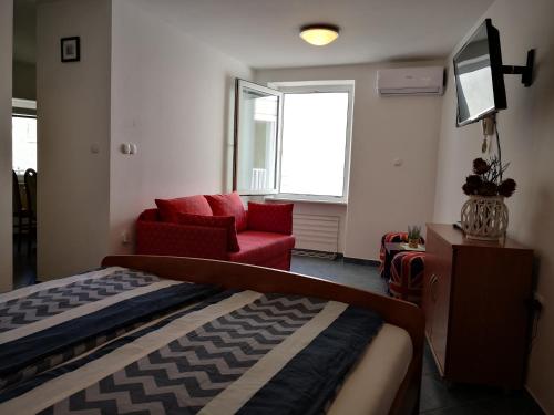 ein Schlafzimmer mit einem Bett, einem Sofa und einem TV in der Unterkunft Galilea 14 in Piran