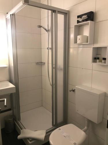a bathroom with a shower and a toilet at bensons hotel in Aachen