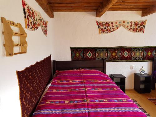 a bedroom with a large bed with a purple blanket at Satu Muscelean in Albeștii de Muscel