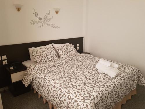 ルートラキにあるGalanopoulos Hotelのベッドルーム1室(ベッド1台、白黒の掛け布団付)