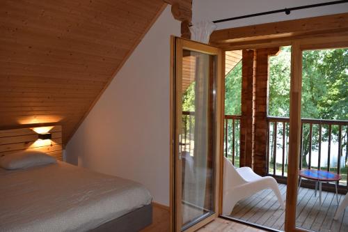 une chambre avec un lit et un balcon dans l'établissement Au bord du lac IV, à Montigny-en-Morvan