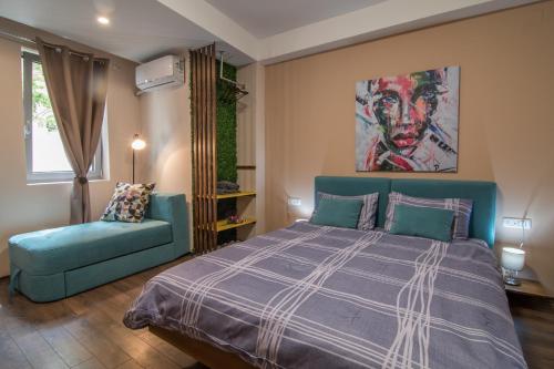 a bedroom with a blue bed and a blue couch at Vanilla Boutique Hotel in Skopje